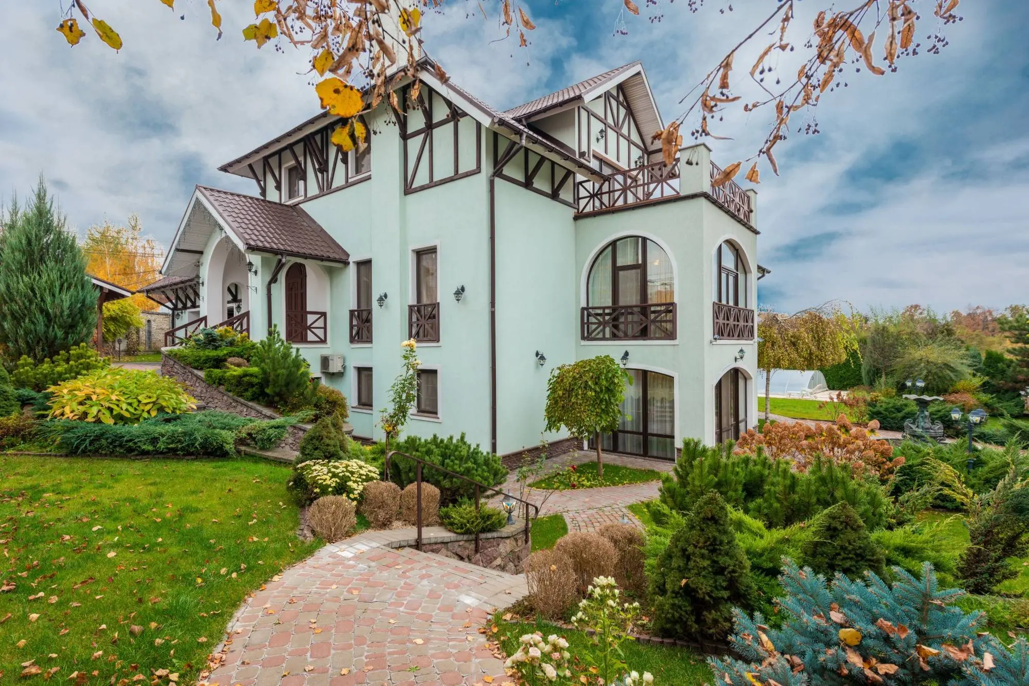 Une maison et son jardin en pente, à l’automne.