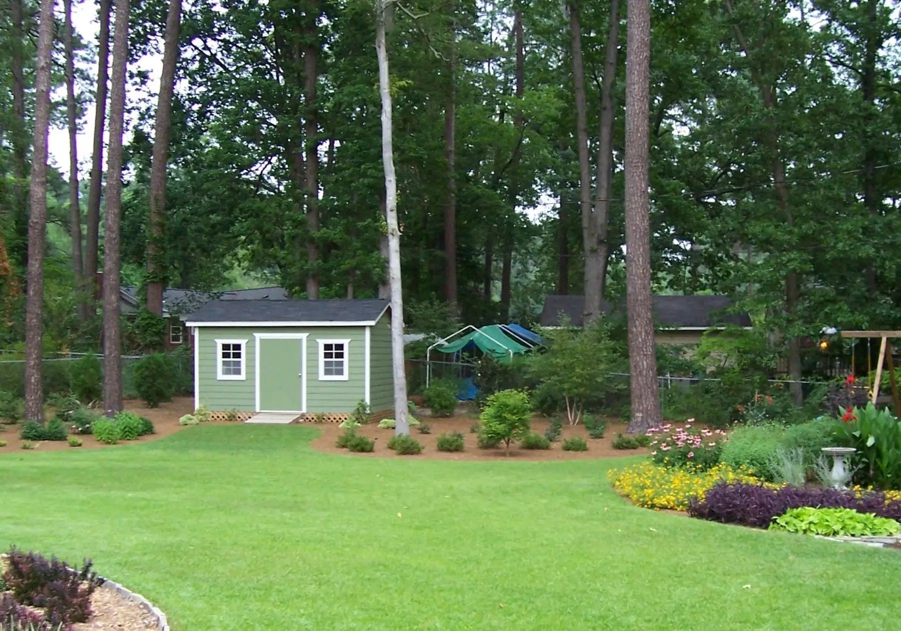 Après : la pelouse redessinée, bordée de massifs paillés et fleuris